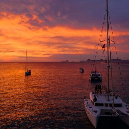 Aerial view from drone on boats shipping in sea, sunset. Yachting with a dramatic sunset as backdrop